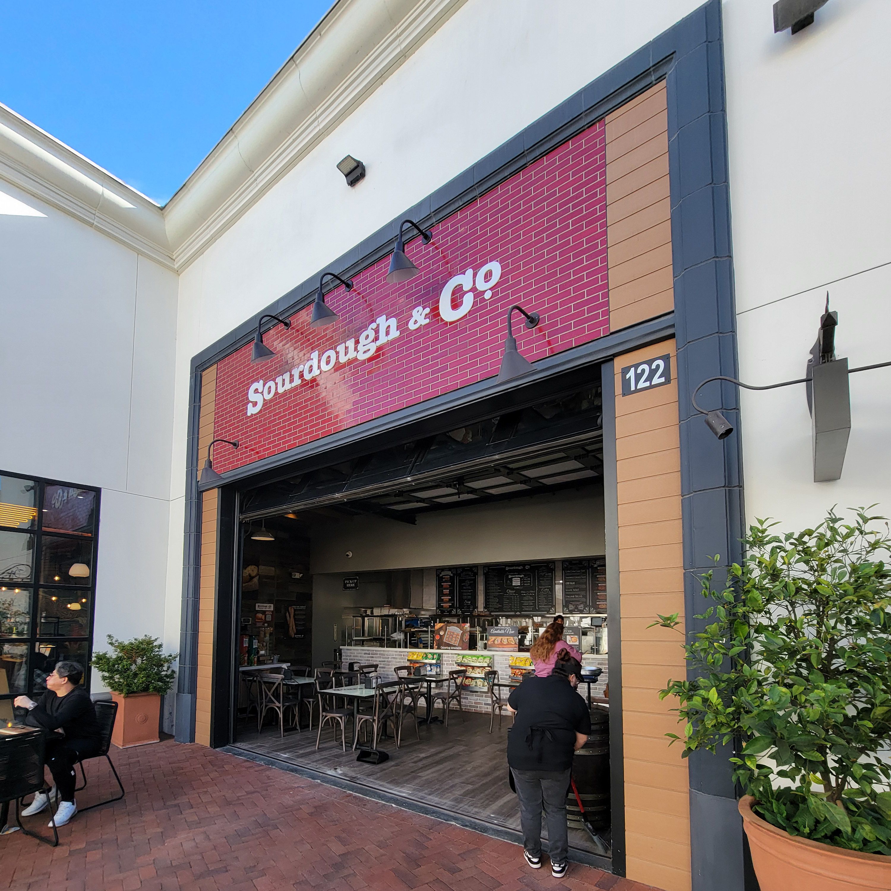 The inviting entrance of Huntington Beach (Inside Bella Tera Mall) Sourdough & Co.) showcasing a menu focused on the best sandwiches, soups, and salads